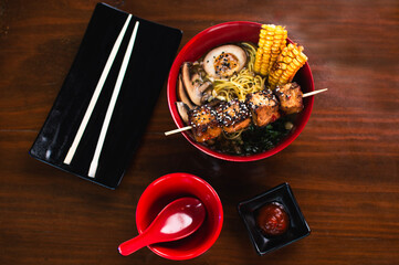 Chicken ramen bowl with corn, mushrooms and grilled skewer