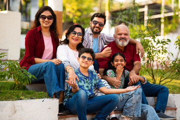 Indian family enjoying outdoor bonding time on steps during weekend relaxation