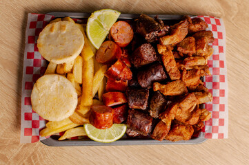 Colombian meat platter with sausages, chicharrón and fries