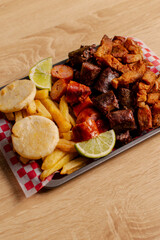 Colombian meat platter with sausages, chicharrón and fries