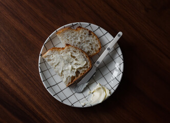 Slices of fresh sourdough bread with butter on a wooden table