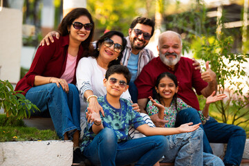 Indian family enjoying outdoor bonding time on steps during weekend relaxation