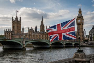 Iconic landmark with Union Jack flag flying showcasing architectural grandeur and a famous clock tower over the river.