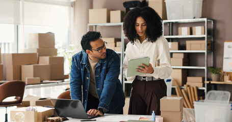 Tablet, laptop and people in meeting for supply chain, online orders and shipping website. Small business, team and man with woman on tech for logistics update, delivery schedule and distribution