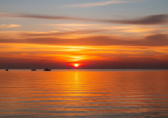 Fototapeta premium Stunning sunset over calm ocean waters, a serene landscape perfect for travel and relaxation