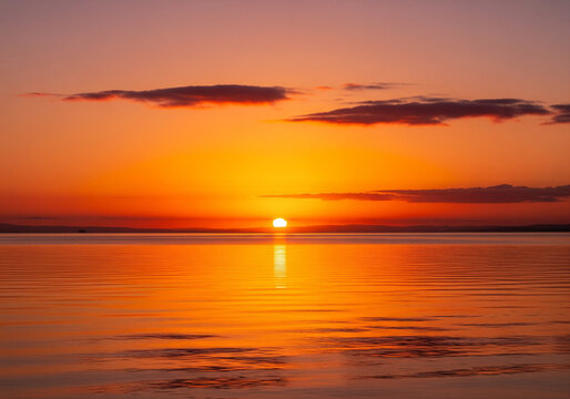 Stunning sunset over calm ocean waters, a serene landscape perfect for travel and relaxation