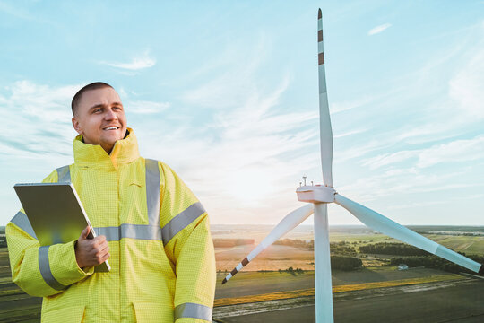 Engineer Inspecting Wind Turbine in Field