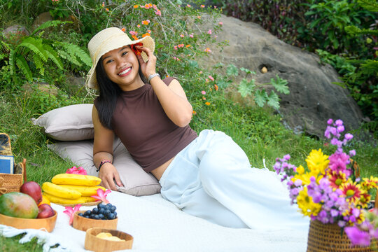 Girl lying on picnic blanket with hat