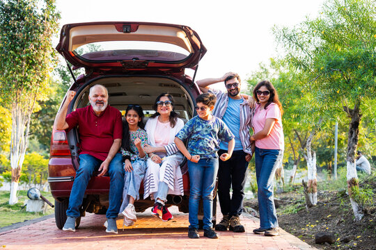 Indian family sitting in car dicky outdoors, enjoying laughter and bonding before a picnic