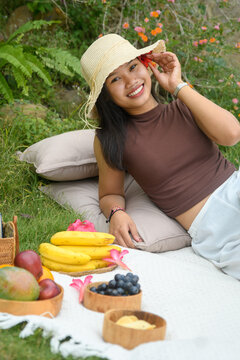 Girl lying on picnic blanket with hat