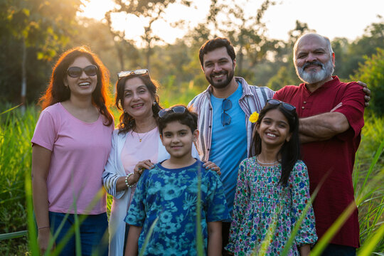 Family camping and playing cricket together, enjoying laughter and bonding in nature - Powered by Adobe