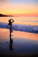 Fototapeta premium 夕焼けの海を眺める彼女