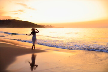 Fototapeta premium 夕焼けの海を眺める彼女