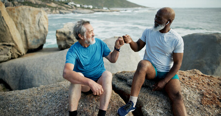 Fitness, rest or people at beach with fist bump, support or cardio break in finished workout. Exercise, mature or friends at ocean with gesture, training recovery or motivation in performance goals.