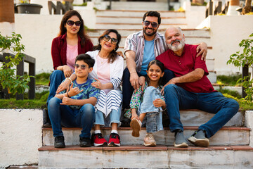 Indian family enjoying outdoor bonding time on steps during weekend relaxation