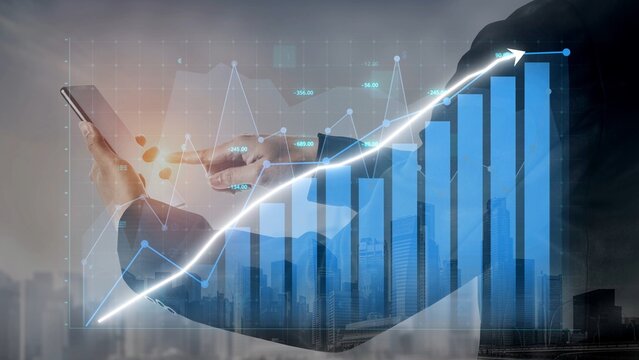 A businessman interacts with a mobile device as financial growth charts and graphs overlay a modern cityscape, representing technology in business and investment. Copula