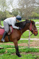 Woman bonding with horse on equestrian outdoor activity