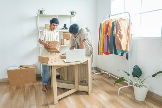 Young Entrepreneurs Diligently Preparing Online Orders Packing Products With Care for Shipment
