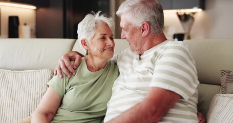 Senior couple, kiss and hug in lounge, people and bonding with smile on couch, retirement and relax. Happy, elderly man and embrace with old woman in living room, affection and romance in house