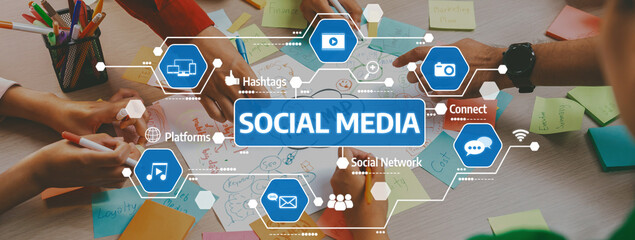 A vibrant workspace showcases hands collaborating on social media strategy, surrounded by colorful notes and digital icons, symbolizing modern communication and creative planning. Amity