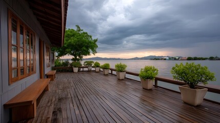 A wooden deck overlooks a serene body of water under a dramatic cloudy sky at twilight