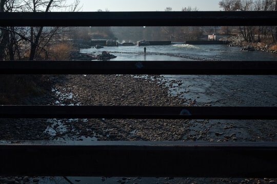 Fisherman wading boise river in winter