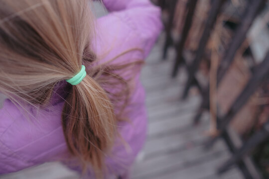 Young girl with blonde hair tied in a ponytail