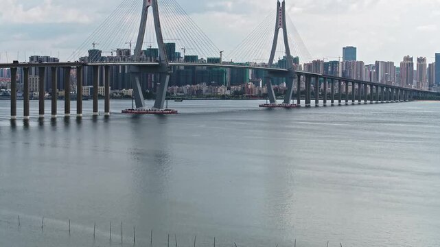 Zhanjiang Bay Bridge spanning across waters with modern city skyline in Guangdong Province, China
