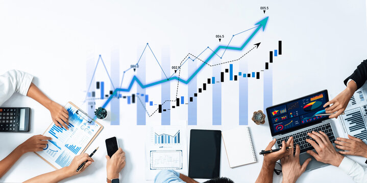 Business team collaborates on financial strategies, analyzing growth charts and data on laptops and notebooks in a modern workspace, showcasing teamwork and productivity. Scalp