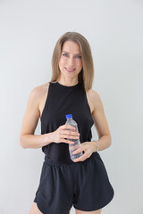 Smiling Woman Holding a Water Bottle, Emphasizing Hydration and Wellness
