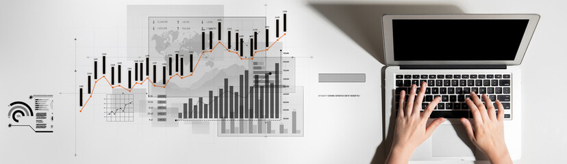 A person operating a laptop keyboard while surrounded by various financial graphs and data...