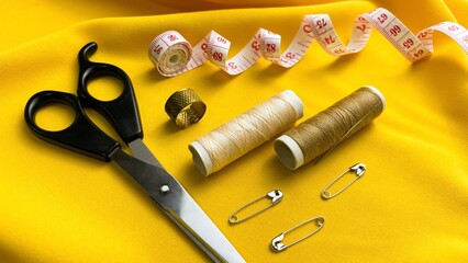 Sewing tools on yellow fabric. Concept: DIY projects, inspiration, DIY clothing creation, repair.