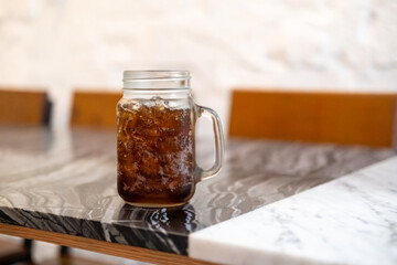 A glass of Cola on the table with bokeh background