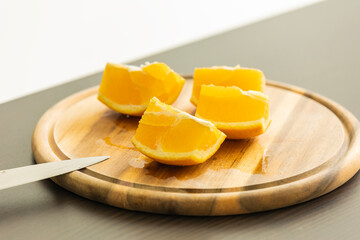 slicing fresh orange on wooden cutting board close-up