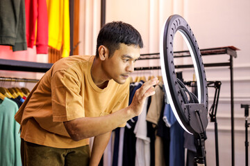 Dynamic Entrepreneur Filming Fashion Haul Video With Ring Light Among Trendy Apparel Displays