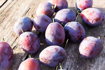 Ripe juicy plums on a wooden table. Close-up. Organic fruit.
