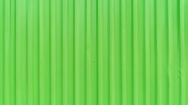 A brightly colored image depicting a textured background with vertical, parallel lines in shades of green