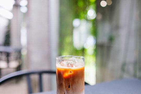 A glass of iced latte coffee on the table in cafe