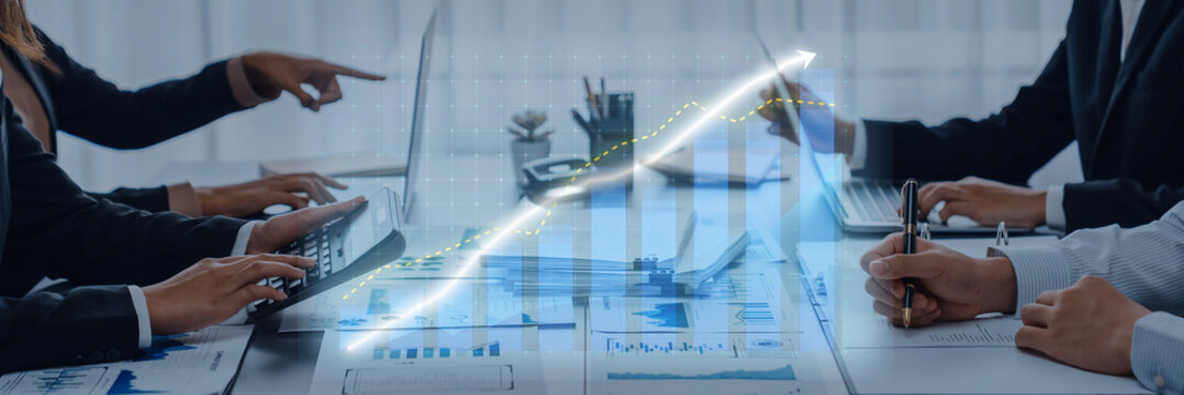 Dynamic scene of business professionals collaborating in a modern office, analyzing graphs and data on laptops to drive growth and strategic decisions. Axiom
