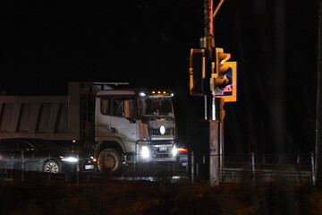 A truck at night in front of a traffic light