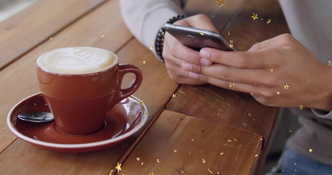 Male patron tapping smartphone beside latte cup, scrolling messages while gold sparkles drifting
