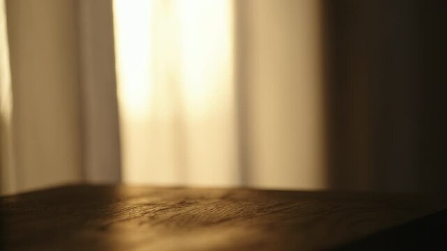 Slow motion focus pull of black wood table with sunset light on background