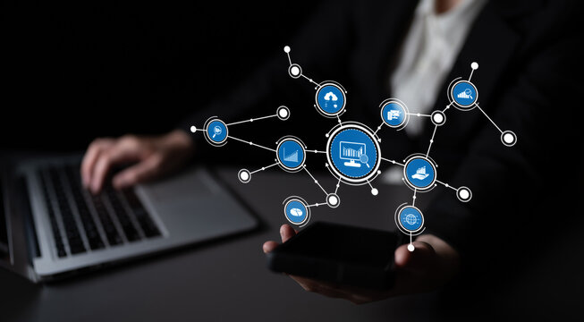 A business professional interacts with a smartphone and laptop amidst a digital network, illustrating technology and modern data visualization in a sleek environment. Tessel