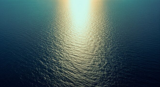 Golden sunlight reflecting on rippling dark blue water surface creating a beautiful textured pattern of light and shadow