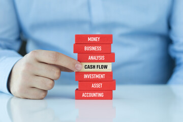 Businessman pointing to cash flow block in stack of finance concept
