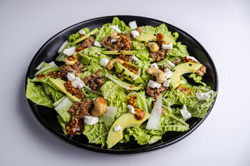 Fresh salad with tuna, avocado, and napa cabbage on a white background