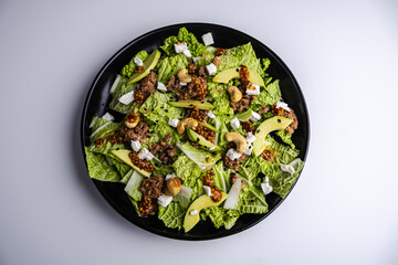 Fresh salad with tuna, avocado, and napa cabbage on a white background
