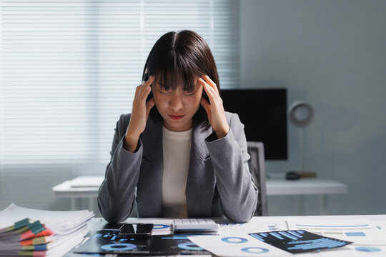 Stressed businesswoman suffering headache from overwork in office