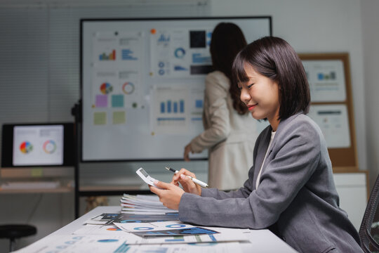 Young asian businesswoman calculating finances during office meeting