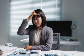 Stressed businesswoman suffering headache working late in office